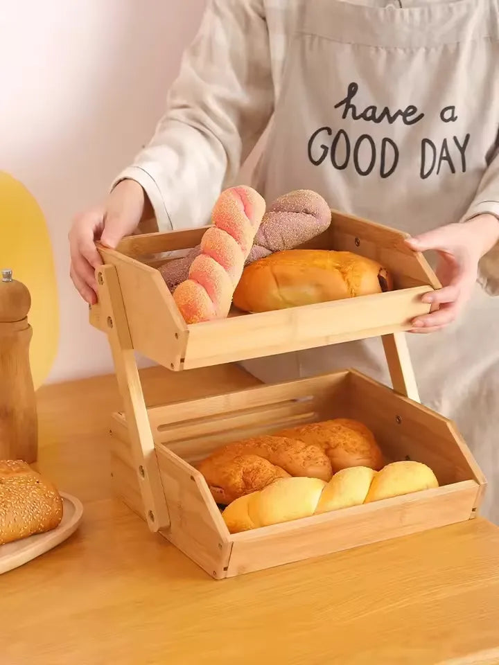 Person holding a wooden bread basket with various bread loaves on a wooden table.