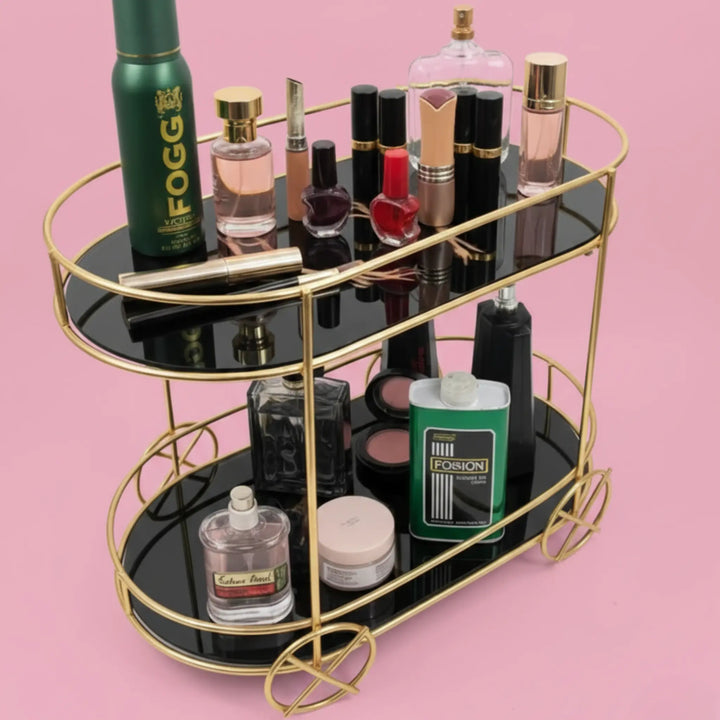 Two-tiered black and gold tray with various cosmetic products on a pink background
