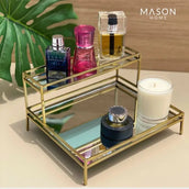 Decorative gold tray with perfumes and a candle on a light background